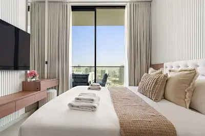 a bedroom with a large white bed with a large window at Silkhaus Modern 1BDR Stay in JVC in Dubai