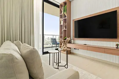 a living room with a couch and a tv at Silkhaus Modern 1BDR Stay in JVC in Dubai