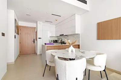 a kitchen and dining room with a table and chairs at Silkhaus Modern 1BDR Stay in JVC in Dubai