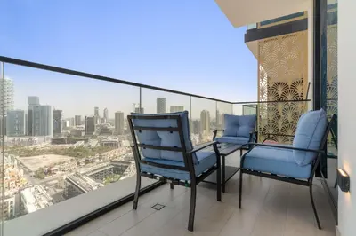 a balcony with two chairs and a view of a city at Silkhaus Modern 1BDR Stay in JVC in Dubai