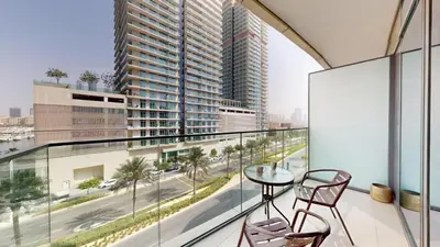 a balcony with a table and two chairs and a view of a city at Beach Vista - One Bed with Infinity Pool Access in Dubai