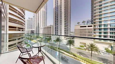 a balcony with two chairs and a table at Beach Vista - One Bed with Infinity Pool Access in Dubai