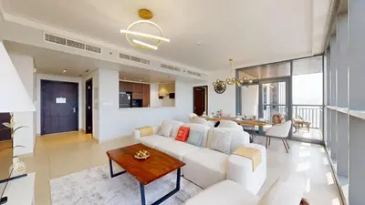 a living room with a white couch and a table at Creek Residences - Opulent Two Bed with Creek View in Dubai