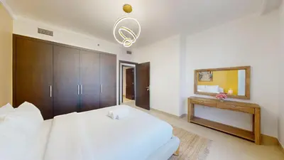 a bedroom with a large white bed and a mirror at Creek Residences - Opulent Two Bed with Creek View in Dubai