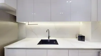 a kitchen with a sink and white cabinets at Binghatti Crescent - Two Bed with Pool View in JVC in Dubai
