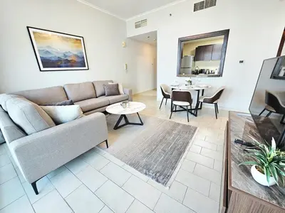 a living room with a couch and a table at Amazing 1BR High-floor with Breathtaking View near Marina Walk in Dubai