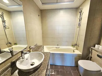 a bathroom with a sink and a tub and a toilet at Amazing 1BR High-floor with Breathtaking View near Marina Walk in Dubai