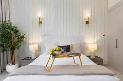 a bed with a table with a bowl of fruit on it at Maison Privee - Stylish Studio with Top Facilities in Damac Hills in Dubai