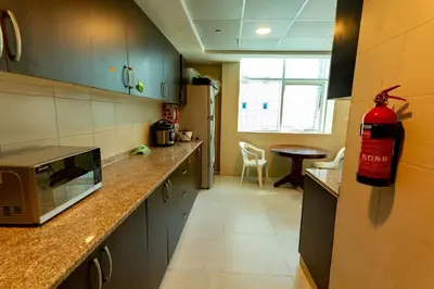 a kitchen with a fire extinguisher on the wall at Rental Small Rooms for female guest in the heart of Dubai بنات فقط in Dubai