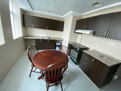 a small kitchen with a wooden table and chairs at Rental Small Rooms for female guest in the heart of Dubai بنات فقط in Dubai