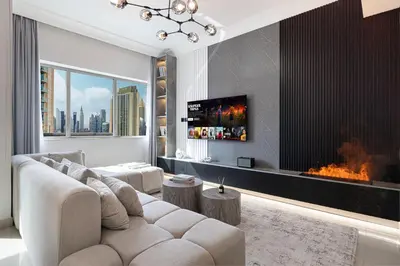 a living room with a couch and a fireplace at Restay Homes at Damac Maison Mall - Full Burj View from all rooms - 1 min to Dubai Mall in Dubai