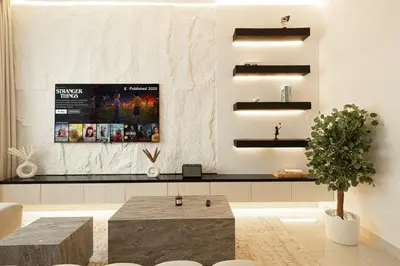 a living room with a tv on a wall at Restay Homes at Damac Maison Mall - Full Burj View from all rooms - 1 min to Dubai Mall in Dubai