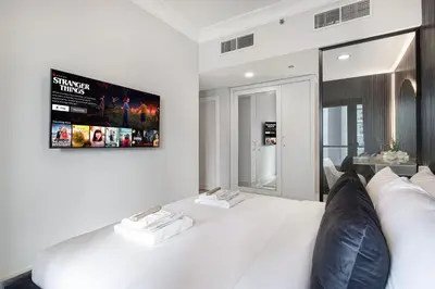a living room with a white couch and a tv at Restay Homes at Damac Maison Mall - Full Burj View from all rooms - 1 min to Dubai Mall in Dubai