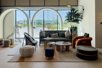 a living room with a couch and a table and chairs at Dubai Hills Cozy 1Br Golfville in Dubai