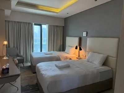 a hotel room with two beds and a window at 2BR Apartment in Paramount Hotel with Burj Khalifa View in Dubai