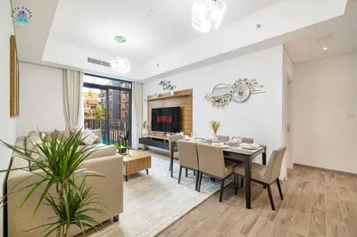 a dining room and living room with a table and chairs at Contemporary 2-BR at Belgravia Square JVC in Dubai