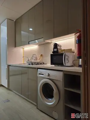 a kitchen with a washing machine and a microwave at EGATE - Studio - 4th Floor - Balcony with a View - 20-423 in Dubai