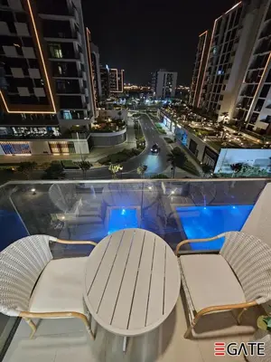 a table and chairs on a balcony at night at EGATE - Studio - 4th Floor - Balcony with a View - 20-423 in Dubai
