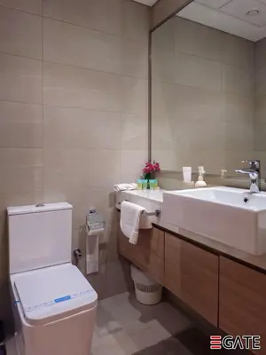 a bathroom with a toilet and a sink and a mirror at EGATE - Studio - 4th Floor - Balcony with a View - 20-423 in Dubai