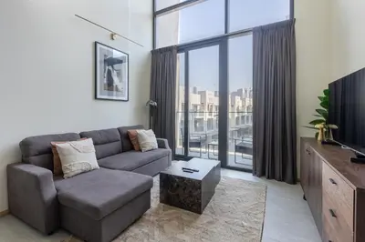 a living room with a couch and a large window at Stylish Duplex Autograph 1BR in Dubai