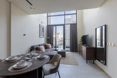 a living room with a table and a couch at Stylish Duplex Autograph 1BR in Dubai