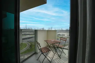 a balcony with a table and chairs looking out a window at EasyGo- City Center, Spacious, Skyline view in Dubai