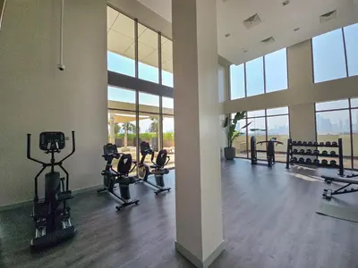 a gym with treadmills and chairs in a building at EasyGo- City Center, Spacious, Skyline view in Dubai