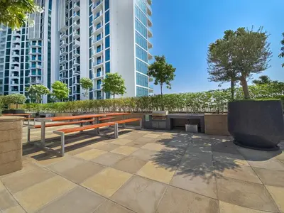 a park with benches and trees and tall buildings at EasyGo- City Center, Spacious, Skyline view in Dubai