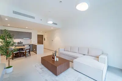 a living room with a white couch and a table at New 1BR Burj view- Infinity Pool - Dubai Mall in Dubai
