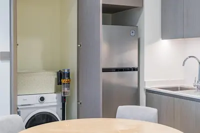 a kitchen with a table and a washer and dryer at New 1BR Burj view- Infinity Pool - Dubai Mall in Dubai