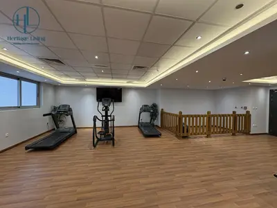 a gym with treadmills and a television in a room at Downtown Living - Business Bay 1BR in Dubai