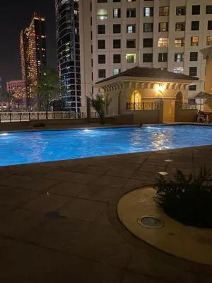 a large swimming pool in a city at night at Alsahel Vacation 1 in Dubai