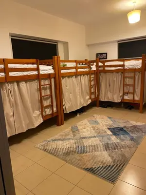 a room with three bunk beds and a rug at Alsahel Vacation 1 in Dubai