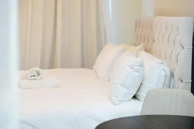 a white bed with a stuffed animal sitting on it at JBR Studio Apartment - Bay Central in Dubai