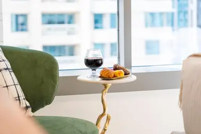 a glass of wine and a plate of food on a table at The Boulevard Suite Stunning Burj Khalifa View Downtown in Dubai