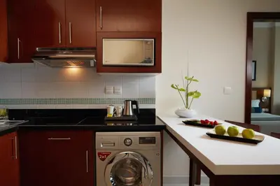 a kitchen with a washer and a counter with a dishwasher at Treppan Hotel & Suites By Fakhruddin in Dubai