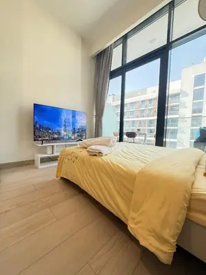 a bedroom with a large bed and a flat screen tv at Cosy studio in Dubai