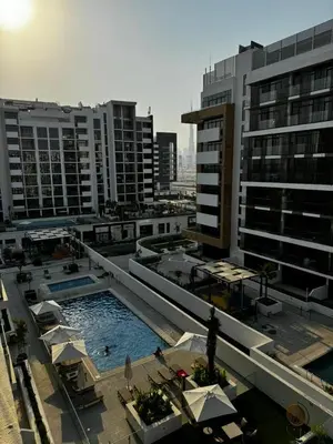 a large swimming pool in a city with buildings at Cosy studio in Dubai