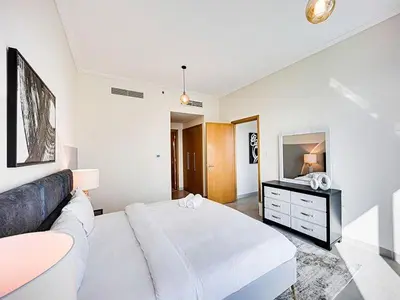 a white bedroom with a large bed and a mirror at Bright 3BR with Maid, Sofa Bed, Marina Views - 32AB02 in Dubai