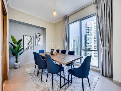 a dining room with a table and chairs and a large window at Bright 3BR with Maid, Sofa Bed, Marina Views - 32AB02 in Dubai