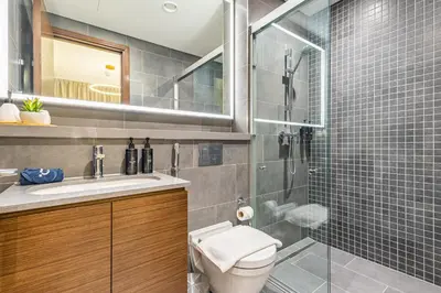 a bathroom with a toilet and a glass shower at Luxury 1BR, The Crest, Sobha Hartland in Dubai