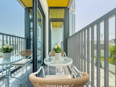 a patio with two tables and chairs on a balcony at Luxury 1BR, The Crest, Sobha Hartland in Dubai