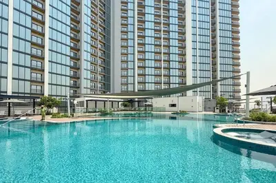 a large swimming pool in front of a large building at Luxury 1BR, The Crest, Sobha Hartland in Dubai