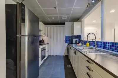 a large kitchen with a stainless steel refrigerator at Shams, JBR - 2BR Apartment - Allsopp & Allsopp in Dubai