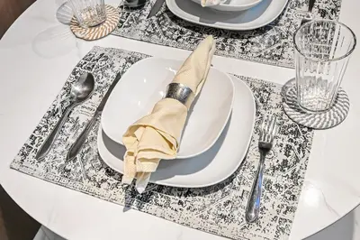 a table with a white plate with a napkin on it at Modern Comfort with Pool and Free Parking Near Dubai Fountain and Burj Khalifa in Dubai