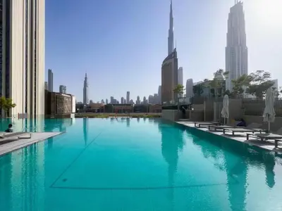 a swimming pool with blue water in a city at Experience the Downtown Views Perfect 2BR wt Balco in Dubai