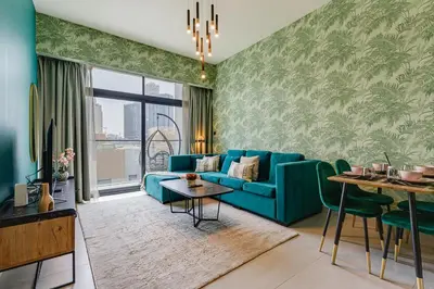 a living room with a blue couch and a table at Oxford Boulevard - 1 BR Apartment - Allsopp & Allsopp in Dubai