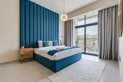a bedroom with a blue bed and a large window at Oxford Boulevard - 1 BR Apartment - Allsopp & Allsopp in Dubai