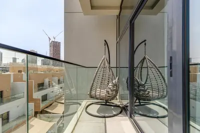 two chairs on a balcony with a view of a city at Oxford Boulevard - 1 BR Apartment - Allsopp & Allsopp in Dubai