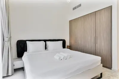 a bedroom with a white bed with two towels on it at Bright 1BR APT in Dubai Hills Near Burj Khalifa in Dubai